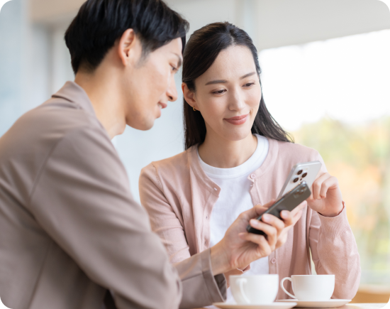 スマートフォンを見ながら相談する男女